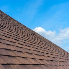 Close up photo of Springdale roofing shingles installed on top of the new modern house under construction against beautiful blue sky
