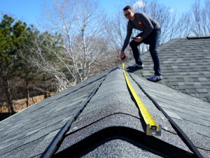 Expert Grove roofing repair pro inspecting roof ventilation system.